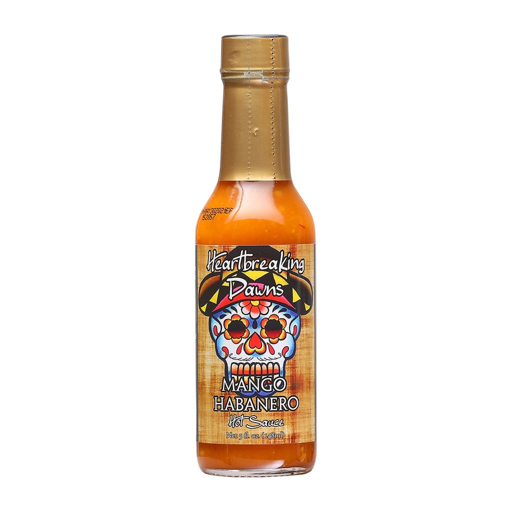Bottle of Heartbreaking Dawn’s Mango Habanero Hot Sauce with colorful skull label and bright orange sauce inside