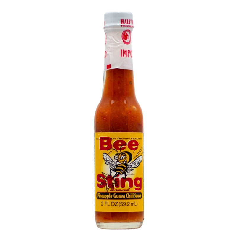 Glass bottle of Bee Sting Pineapple Guava Chili Sauce with yellow label and bee graphic; filled with orange tropical chili sauce; 2 fl oz size.
