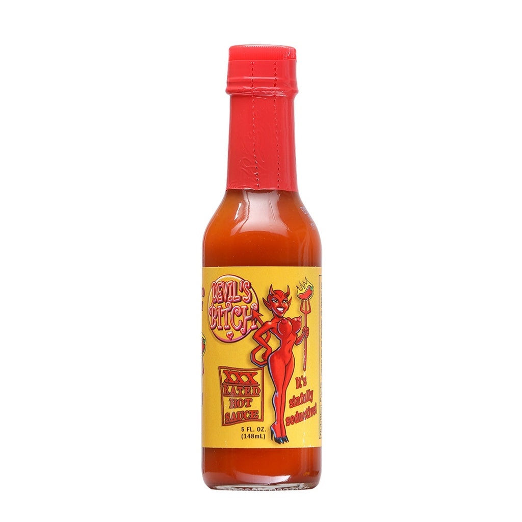 A 5 fl oz bottle of Devil’s Bitch XXX Rated Hot Sauce. The sauce is a deep red-orange color and the bottle is topped with a bright red wax-style seal. The yellow label features a cartoon devil woman holding a fiery pitchfork, with bold text reading “Devil’s Bitch” and “XXX Rated Hot Sauce.” Additional text on the label says “It’s Sinfully Seductive!”