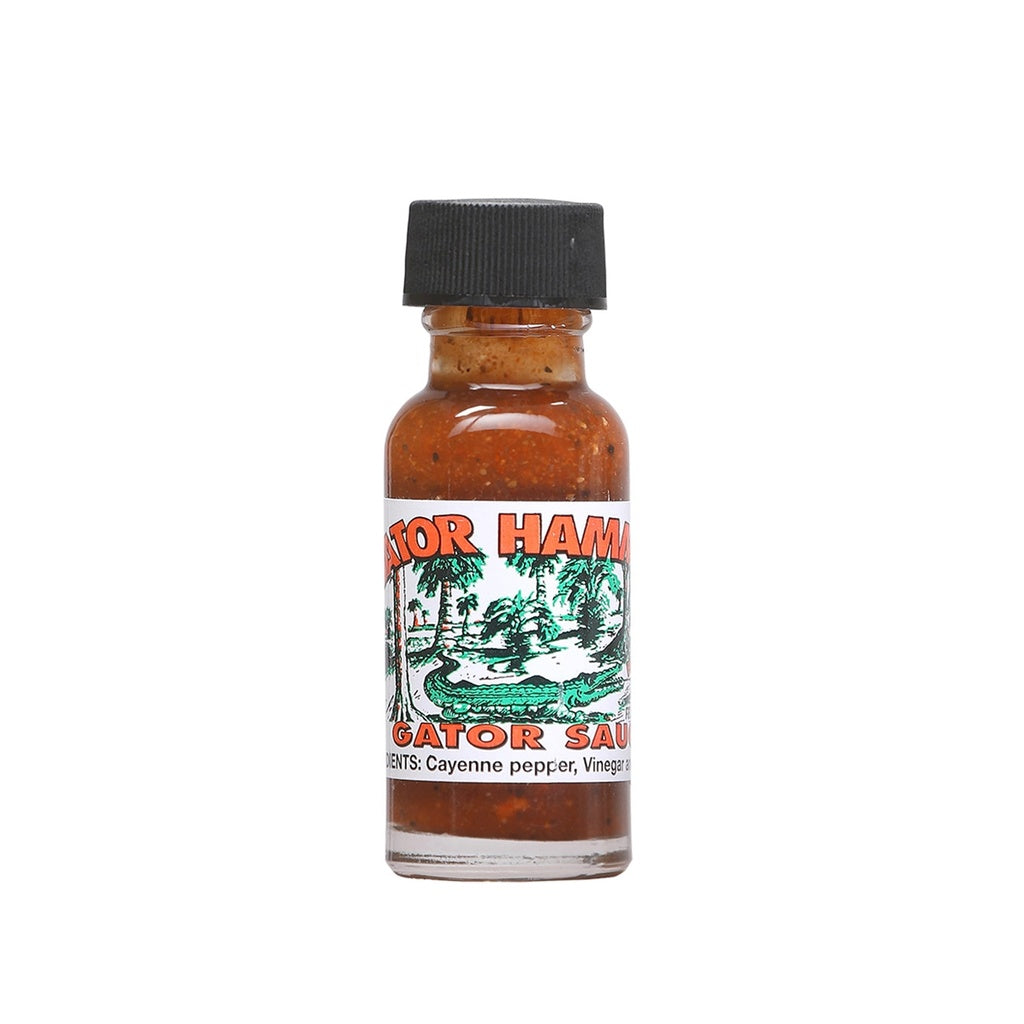 Small glass bottle of Gator Hammock Gator Sauce Mini hot sauce with black cap and green alligator label, 0.5 fl oz bottle shown on white background. UPC GatorHammockMiniHotSauce
