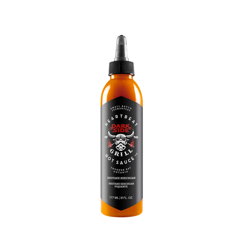 Tall squeeze bottle of Heartbeat Darkside of the Grill Shiitake Szechuan Hot Sauce with black label, stormtrooper-style grill graphic, and orange sauce visible; labeled 6 fl oz / 177 mL.