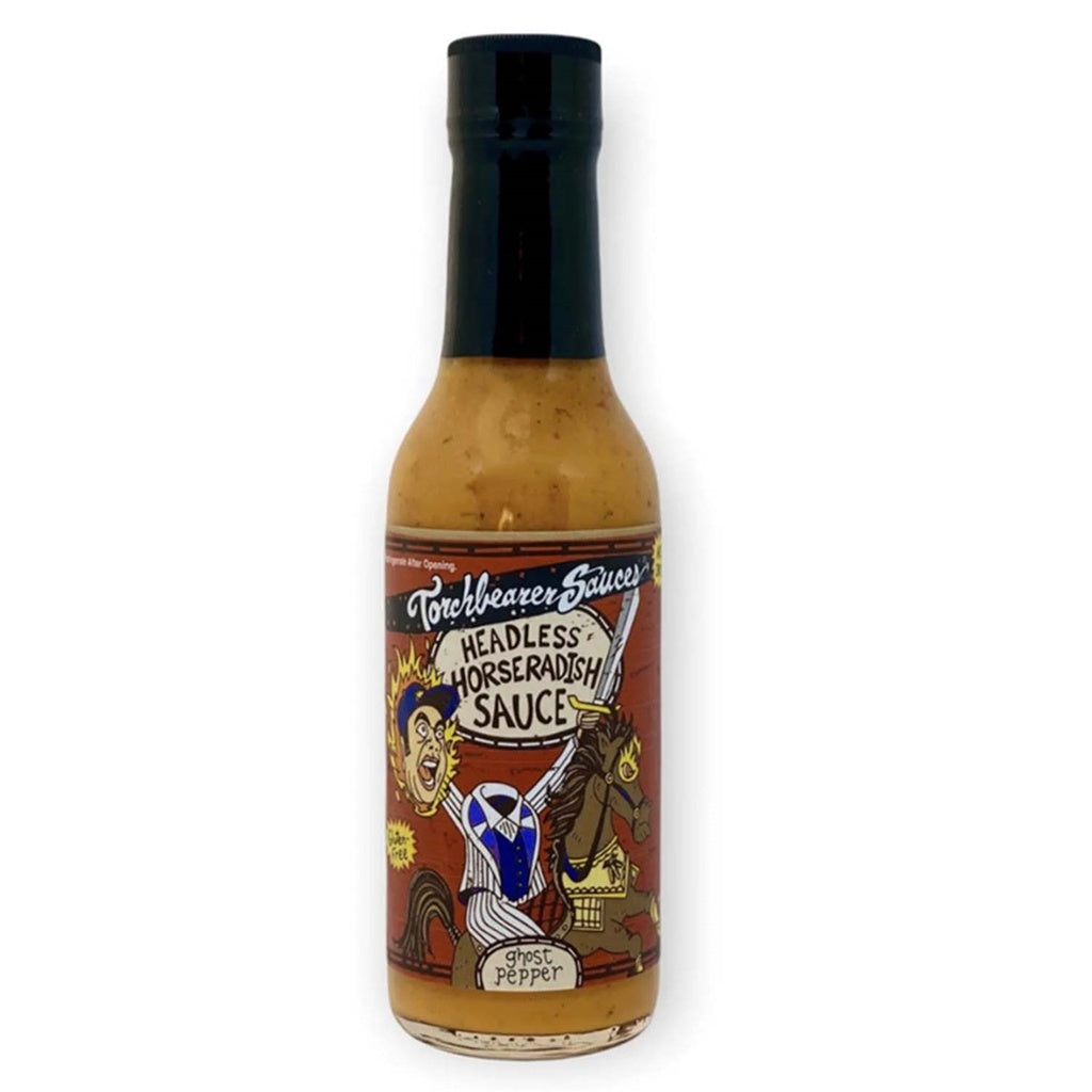 A bottle of Torchbearer Headless Horseradish Sauce with a black cap and tan-colored sauce inside. The label shows a cartoon headless horseman holding a sword while riding a horse, with bold hand-drawn text reading āHeadless Horseradish Sauceā and āGhost Pepper.ā
