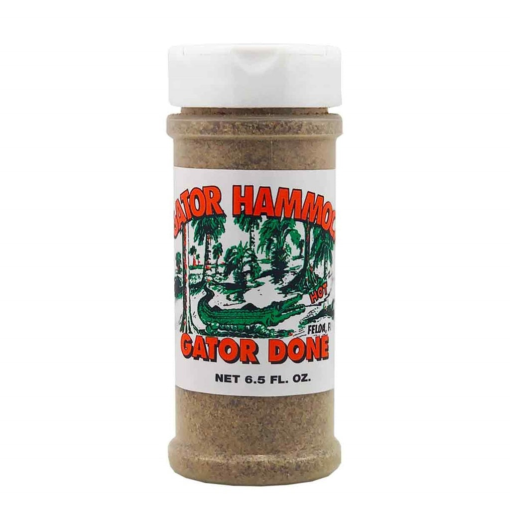 A plastic shaker bottle of Gator Hammock Gator Done seasoning with a white label showing a green alligator swamp scene and the words “Gator Done,” net 6.5 fl oz. UPC 748309111057.