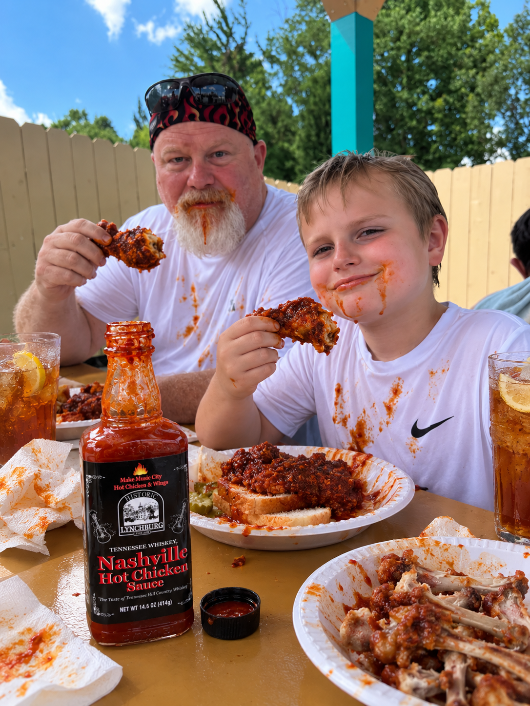 Historic Lynchburg Tennessee Whiskey Nashville Hot Chicken Sauce with Nashville hot chicken on white bread, iced tea, and a family enjoying a spicy meal.