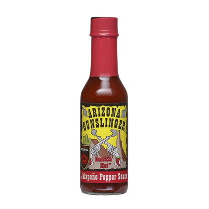 A 5-ounce bottle of Arizona Gunslinger Smokin’ Hot Jalapeño Pepper Sauce. The bottle has a red cap and a bright yellow label featuring two crossed revolvers, a cactus, and Western-style lettering. The sauce inside is a deep red color.
