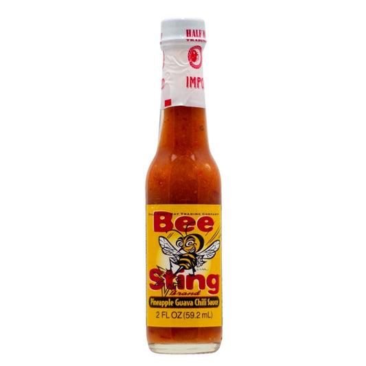 Glass bottle of Bee Sting Pineapple Guava Chili Sauce with yellow label and bee graphic; filled with orange tropical chili sauce; 2 fl oz size.