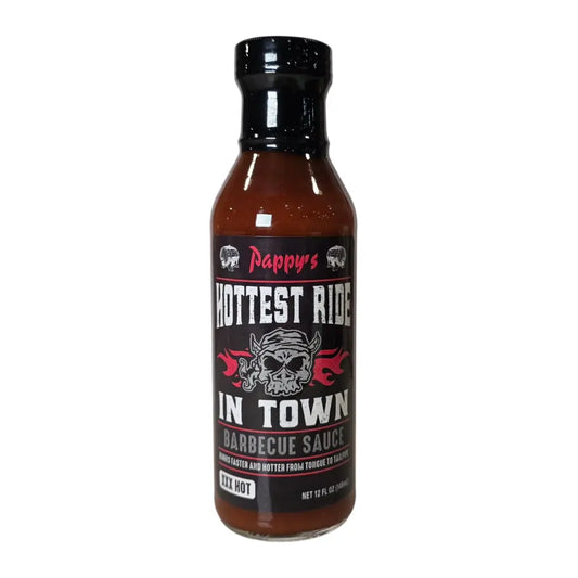 A bottle of Pappy’s Hottest Ride in Town Barbecue Sauce (XXX Hot). The sauce is dark reddish-brown and comes in a 12 fl oz bottle with a black cap. The label is black with bold distressed white text, red flame graphics, and a horned skull illustration, emphasizing the extreme heat level.