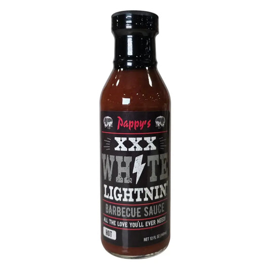 A 12 fl oz bottle of Pappy’s XXX White Lightnin’ Barbecue Sauce. The bottle has a black cap and a dark label with bold distressed text. The label reads “Pappy’s” at the top in red script, followed by “XXX White Lightnin’” with a white lightning bolt graphic. The bottom of the label says “Barbecue Sauce” and the tagline “All the love you’ll ever need!” A small box indicates the heat level as “Hot.”