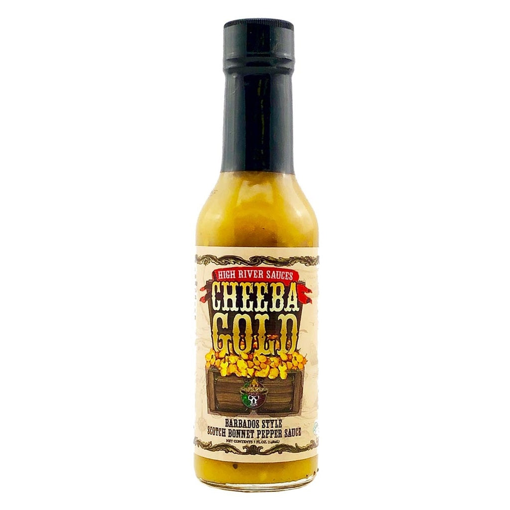 A bottle of High River Sauces Cheeba Gold Barbados Style Scotch Bonnet Pepper Sauce. The bottle contains a golden-yellow sauce and has a black cap. The label features rustic, vintage-style text reading “Cheeba Gold” above an illustration of a wooden chest overflowing with gold. Additional text reads “Barbados Style Scotch Bonnet Pepper Sauce” and “High River Sauces.”