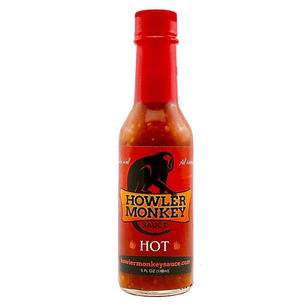 Bottle of Howler Monkey hot sauce with a red cap on a white background
