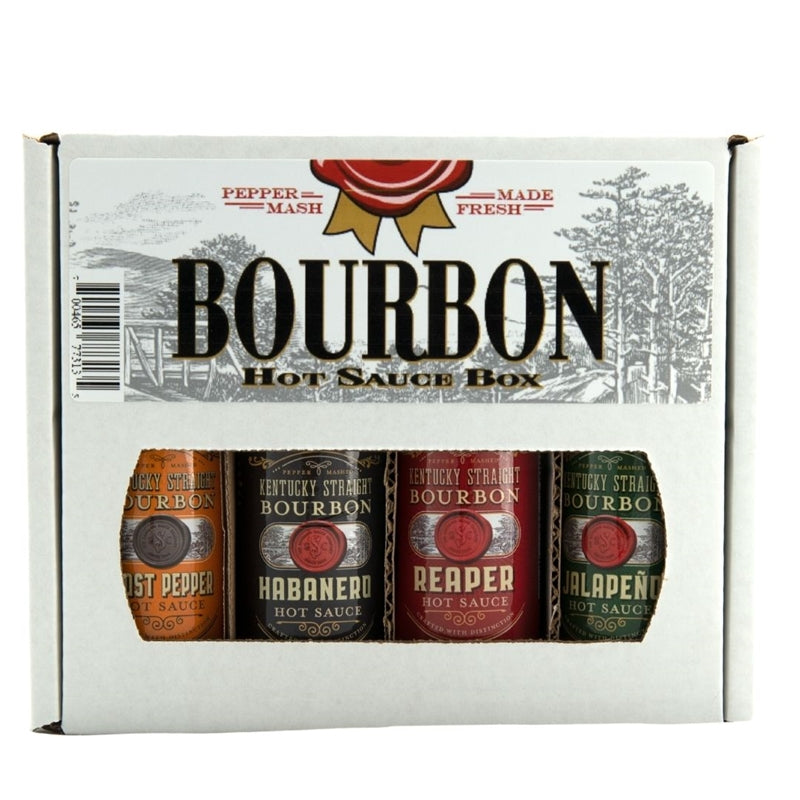 A boxed Kentucky Straight Bourbon Hot Sauce 4-pack set displayed in a white gift carton labeled “Bourbon Hot Sauce Box.” The front window shows four bottles in different flavors: Ghost Pepper (orange label), Habanero (black label), Reaper (red label), and Jalapeño (green label).