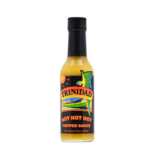 A bottle of Trinidad Hot Hot Hot Pepper Sauce, featuring a vibrant label with the Trinidad logo, an illustration of peppers, and the colors of the Trinidad and Tobago flag. The 5 oz. bottle contains a blend of habanero peppers, onions, vinegar, green peppers, celery, mustard, ginger, garlic, salt, thyme, basil, and other fine herbs. UPC: 095488100021.