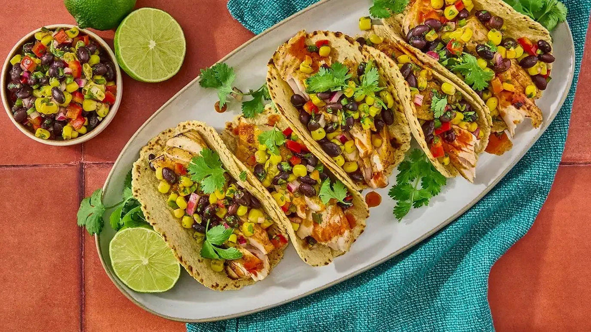 Cholula Chili Lime Hot Sauce, featuring Guajillo, shown with prepared tacos in a manufacturer lifestyle setting